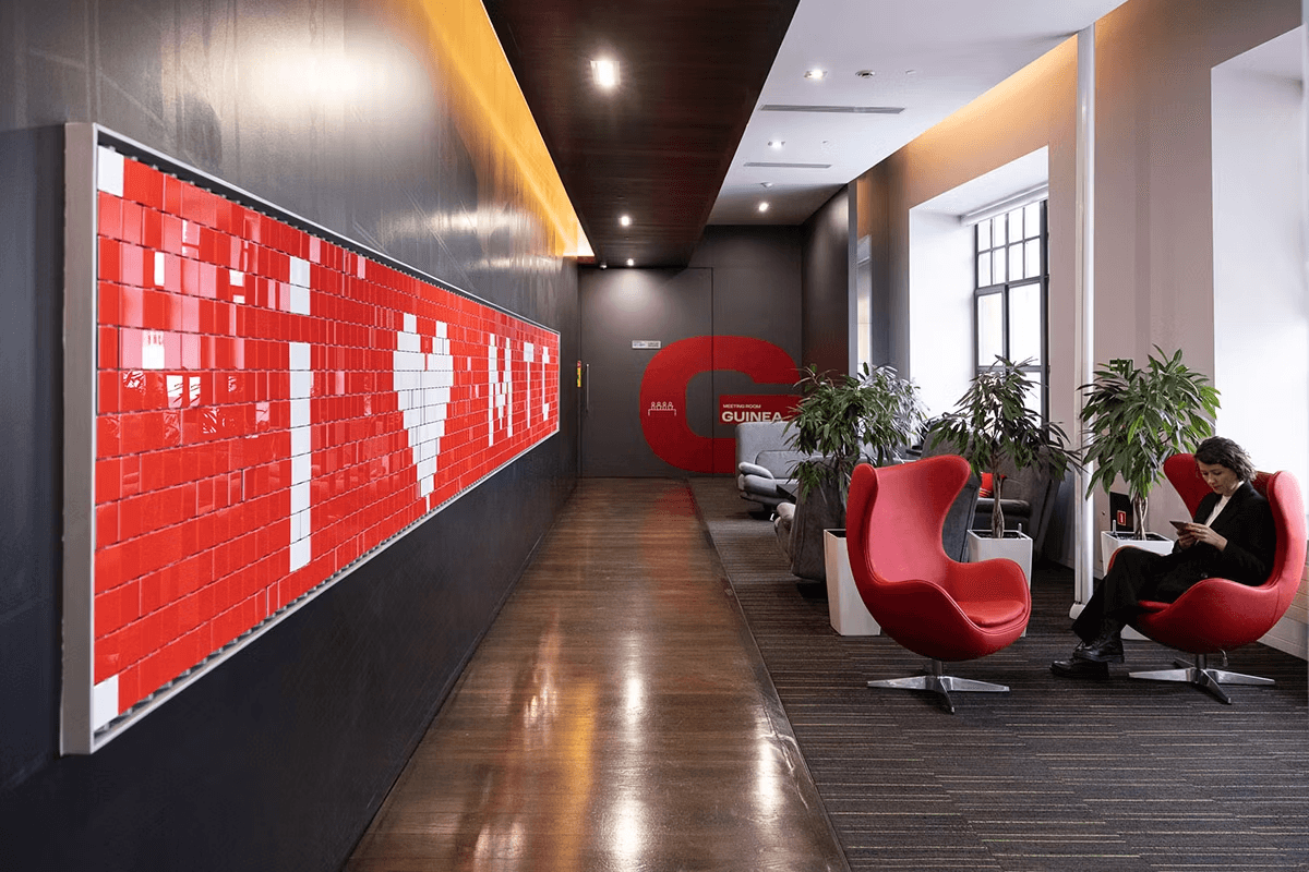 A mysteriously smiling woman covers her face with a newspaper